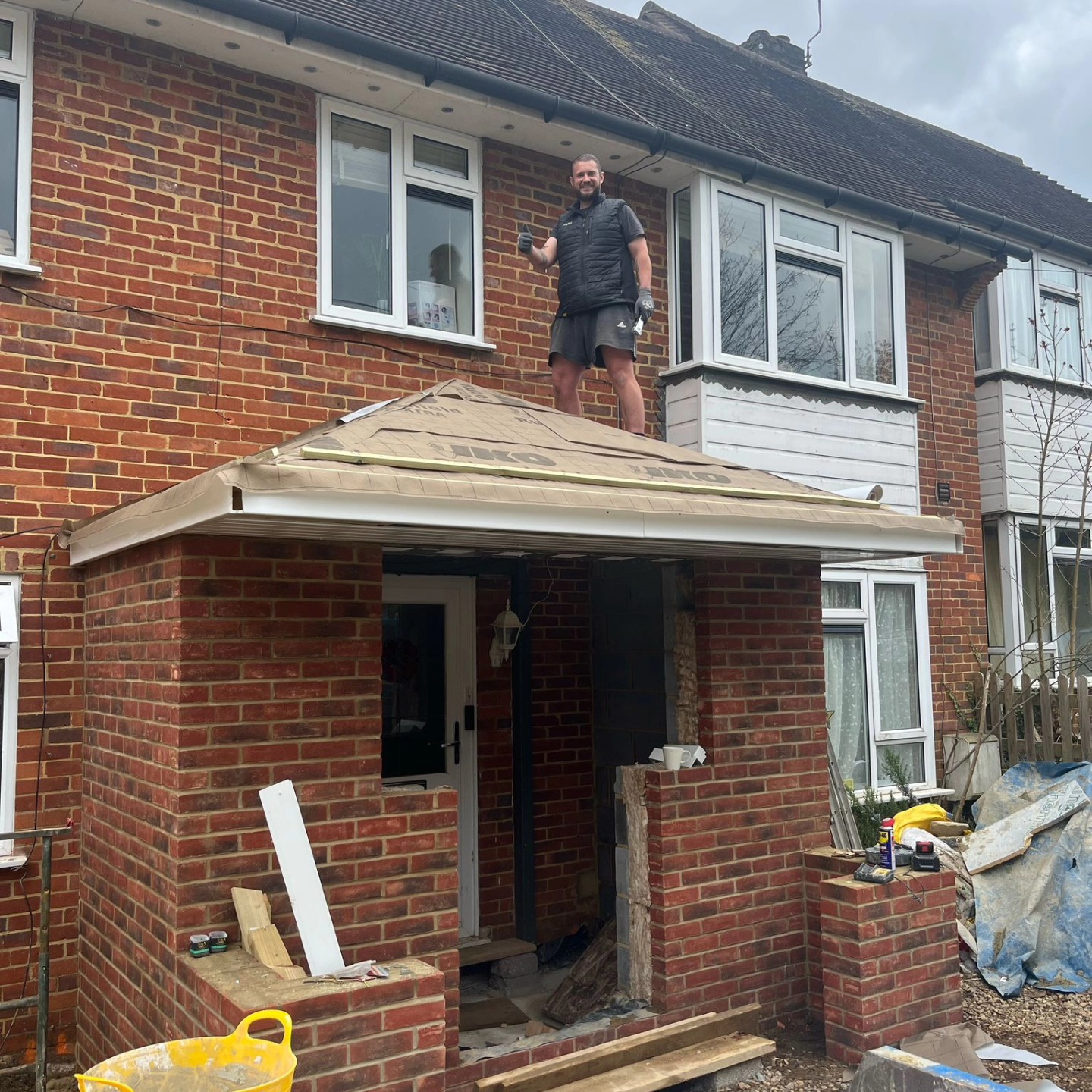 Builder on site working on a porch construction project — the kind of construction work where CIS obligations apply
