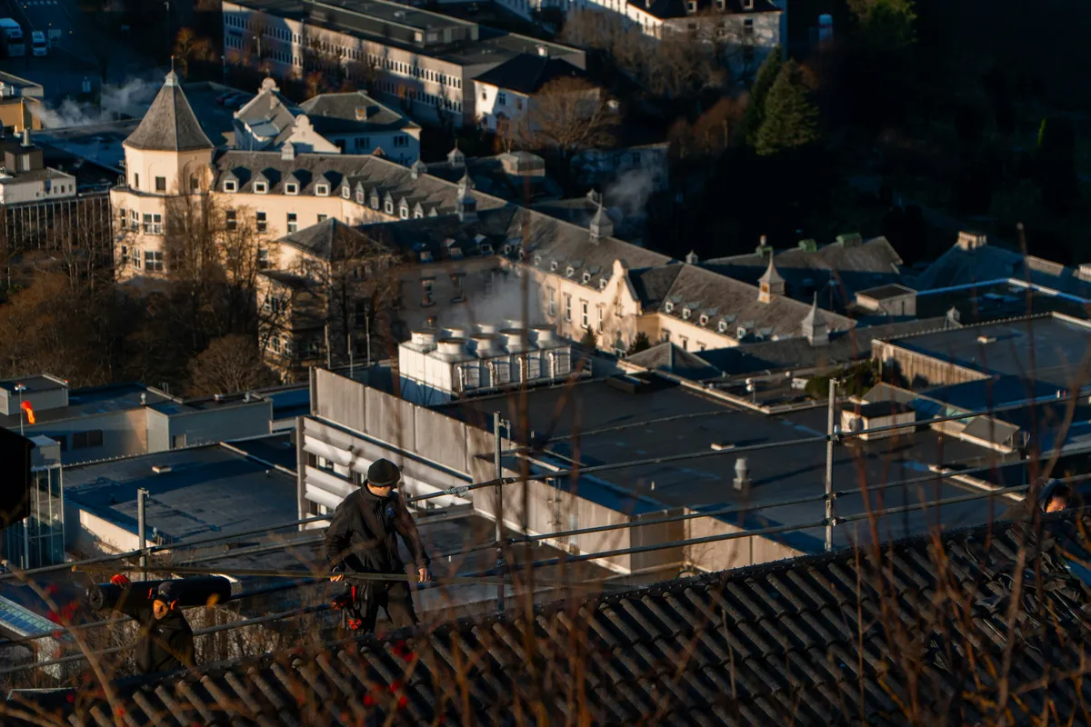 Roofer on scaffolding with city backdrop