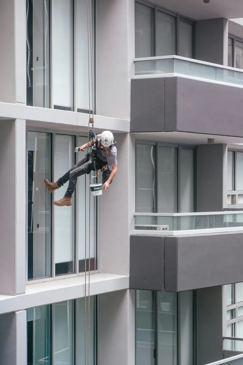 Rope access painter working on a high-rise building